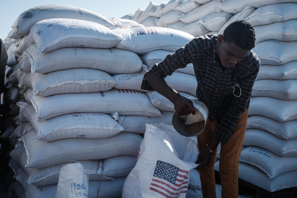 Un hombre reparte la contribución alimentaria de la Usaid para refugiados etíopes en el este de Sudán, en una imagen de archivo de 2020