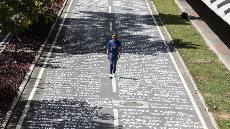 Un estudiante de la Universidad Central de Venezuela camina sobre los nombres, pintados en el piso, de los jóvenes fallecidos en las protestas antigubernamentales desde 2014, en Caracas el 12 de febrero de 2025