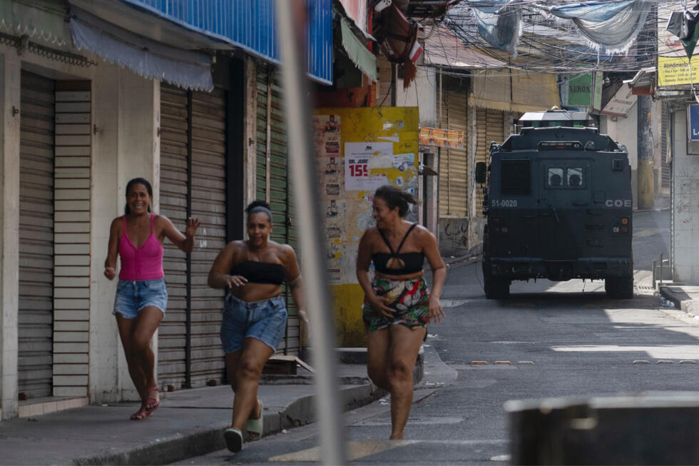 (ARCHIVO) Tres mujeres en la favela Complexo do Alemao, en Rio de Janeiro, durante un patrullaje el 24 de enero de 2025.