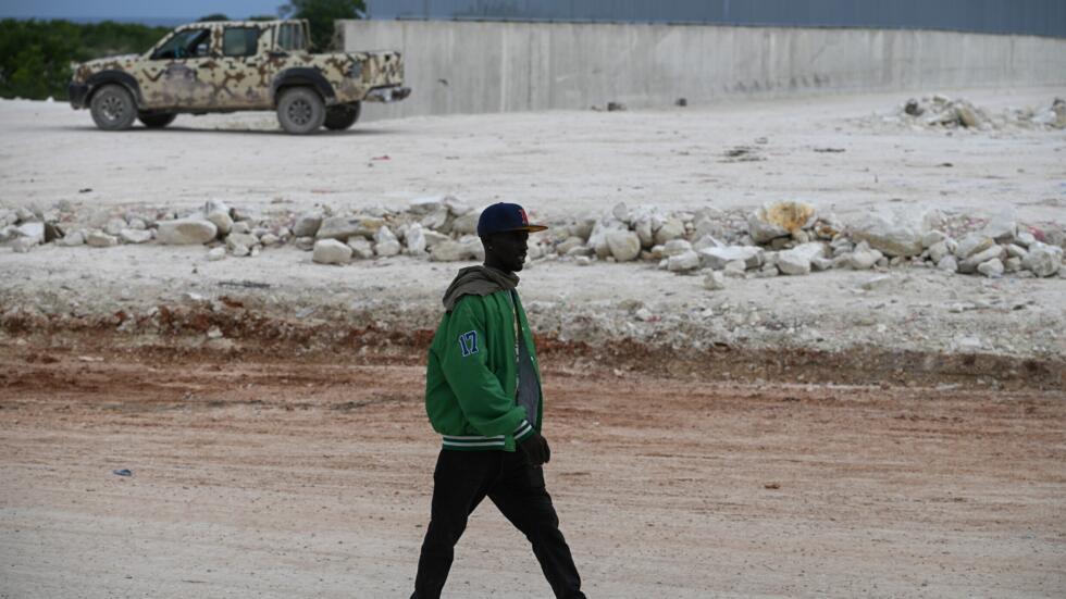 Un haitiano camina junto al muro en construcción en la frontera con República Dominicana, en la localidad dominicana de Pedernales, el 15 de mayo de 2024