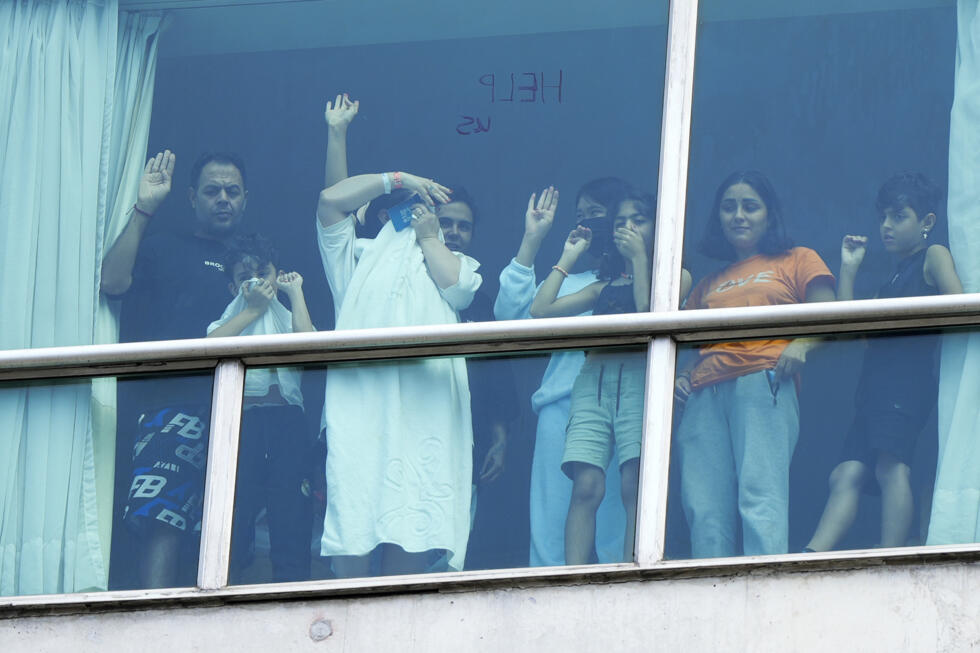 Migrantes deportdos a Panamá desde Estados observan por una ventana del hotel Decápolis de la Ciudad de Panamá el 18 de febrero de 2025.