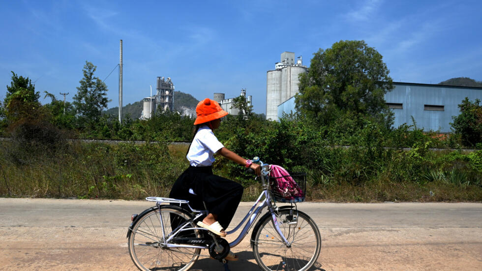 Una escolar pedalea en su bicicleta cerca de la fábrica de cemento Chip Mong Insee, en la provincia camboyana de Kampot, el 9 de enero de 2025