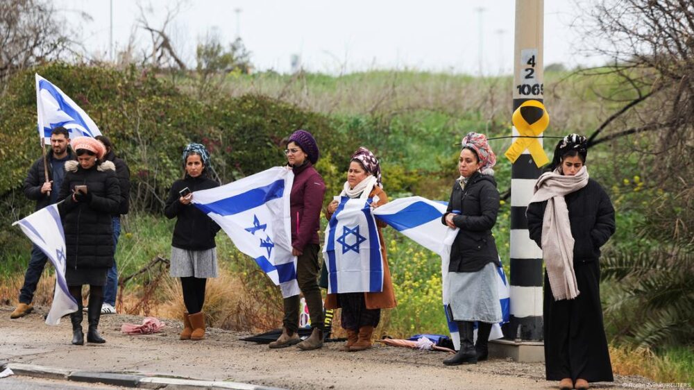 Israelíes sosteniendo banderas del país esperaron el paso del convoy que transportaba los cuerpos sin vida de los rehenes isarelíes Oded Lifschitz, Shiri Bibas y sus dos hijos, Kfir y Ariel Bibas.