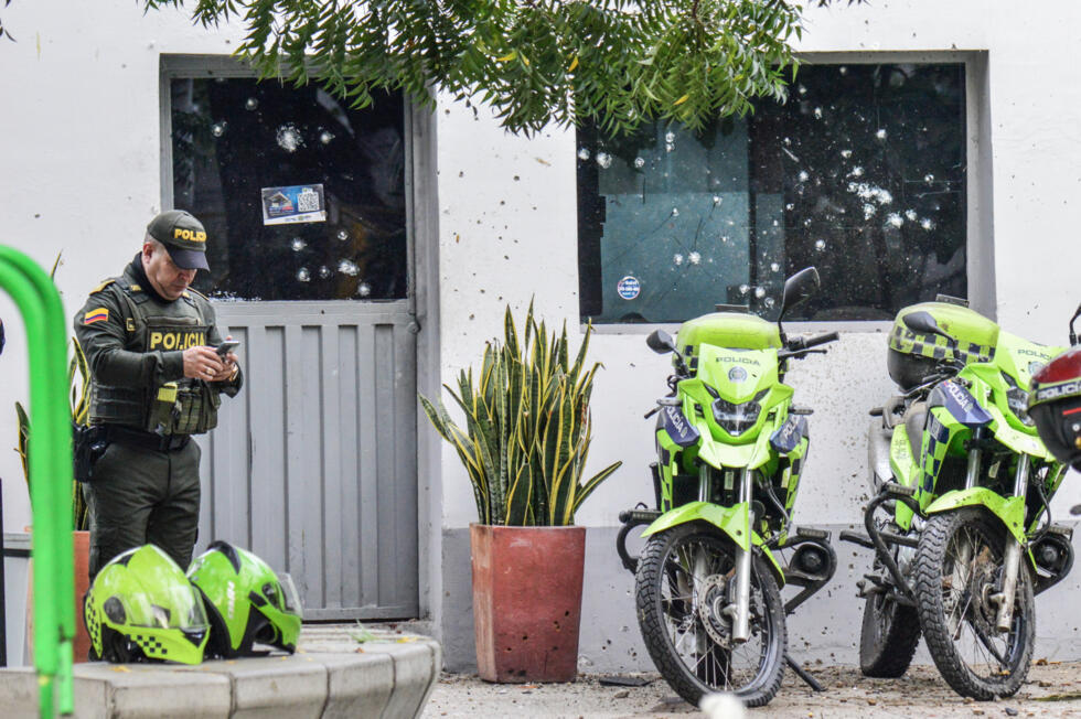 Un agente de policía frente a una caseta de policía de los Comandos de Atención Inmediata (CAI) dañada tras ser atacada con explosivos en Cúcuta, provincia de Norte de Santander, Colombia, el 20 de febrero de 2025.