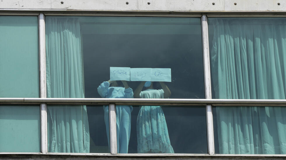 Migrantes deportados de EEUU colocan papeles con un mensaje escrito en la ventana del Hotel Decápolis donde se hospedan temporalmente en Ciudad de Panamá, 18 de febrero de 2025