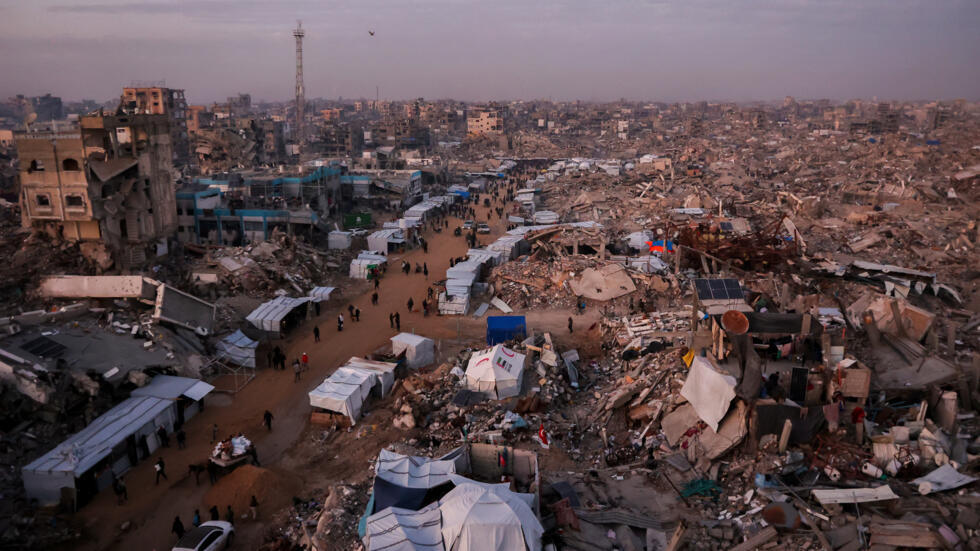 Palestinos caminan entre tiendas instaladas en una calle devastada en Jabaliya, en la Franja de Gaza, el 18 de febrero de 2025