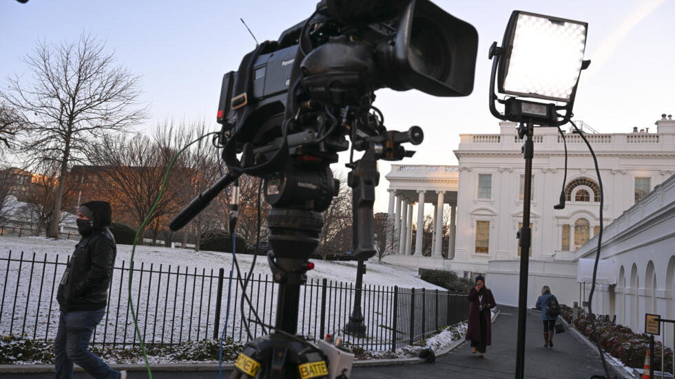 Una cámara y un foco enfocan hacia la Casa Blanca, en Washington, el 20 de enero de 2025