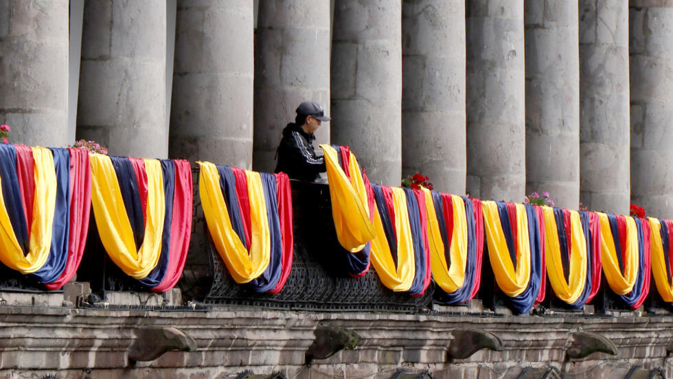 Una persona cuelga unas banderas de Ecuador en el balcón del palacio de gobierno, en Quito, el 5 de enero de 2025