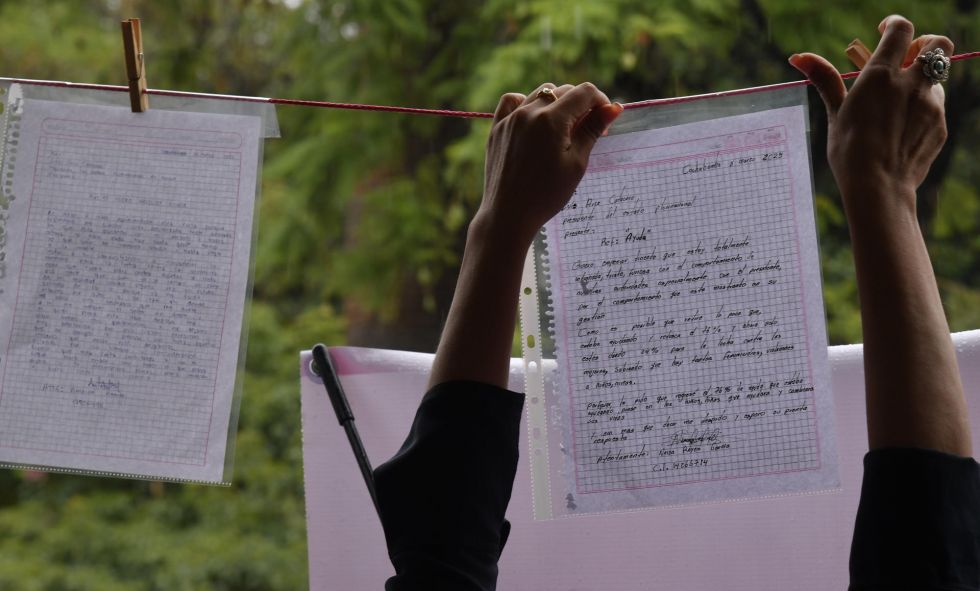 Una mujer cuelga una carta durante un evento este lunes, en la plaza 14 de septiembre en Cochabamba (Bolivia).