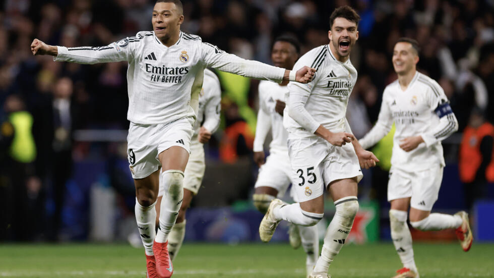 Kylian Mbappé (izquierda) y Raúl Asencio (centro, primer plano) festejan la tanda de penales ganada por el Real Madrid ante el Atlético en octavos de final de la Liga de Campeones. En Madrid, el 12 de marzo de 2025