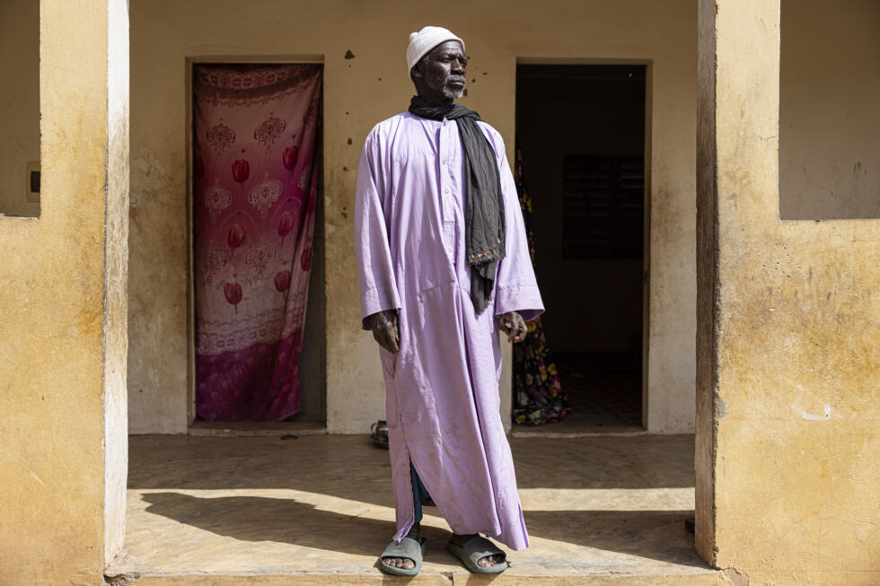 Ibrahima Ba, agricultor desplazado por la explotación minera realizada en el norte de Senegal en una concesión otorgada al grupo minero francés Eramet, posa el 11 de febrero de 2025 para un retrato frente a su casa en el pueblo de los "reubicados" de Foth, un pueblo construido por Eramet Grande Côte (EGC), filial de Eramet en Senegal, para reubicar a los campesinos desplazados por el proyecto minero y sus familias