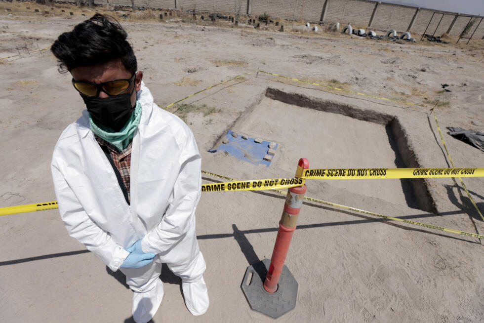 Un forense se para frente una zona de acceso prohibido en el rancho "Izaguirre", localidad de Tehuchitlan, estado mexicano de Jalisco, el 20 de marzo de 2025