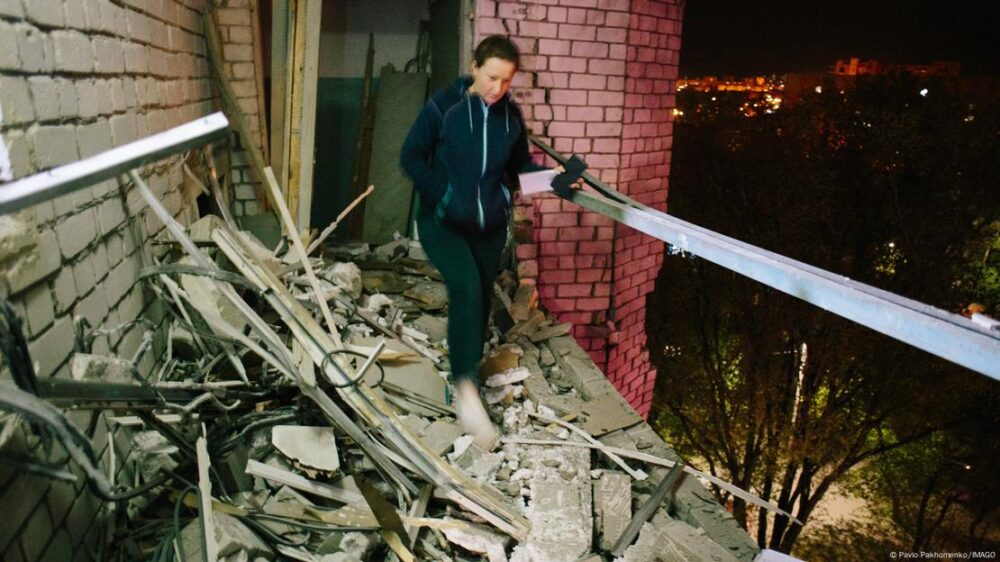 Una residente camina por un balcón dañado por un dron para llegar a su apartamento en Járkov, Ucrania. (Imagen de archivo: 29.04.2025)