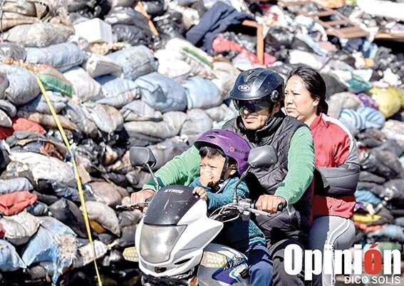 Una familia atraviesa una montaña de desechos en la avenida Humboldt. / DICO SOLÍS