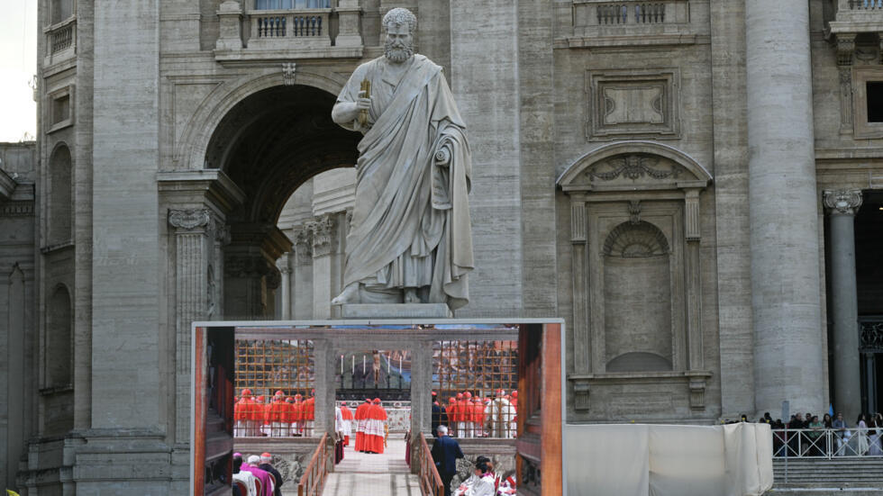 Una pantalla gigante instalada en la Plaza de San Pedro, en Ciudad del Vaticano, muestra a los cardenales en una misa en la Capilla Sixtina el 7 de mayo de 2025, primer día del cónclave para elegir al nuevo papa