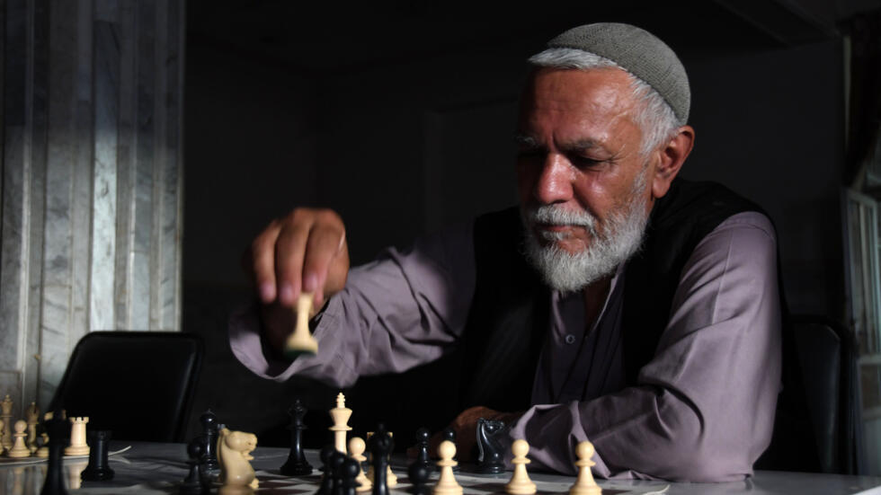 Un jugador mueve una pieza durante una partida de un torneo de ajedrez en Kandahar, el 30 de junio de 2022 al sur de Afganistán