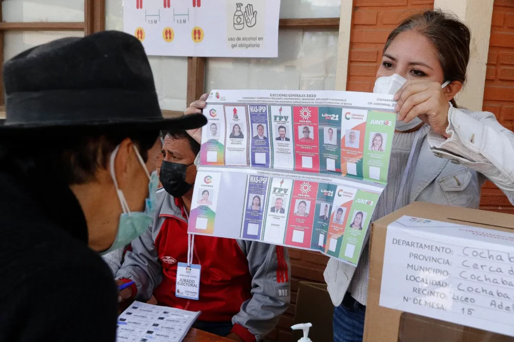Una jurado de mesa muestra la papeleta de votación en 2020.