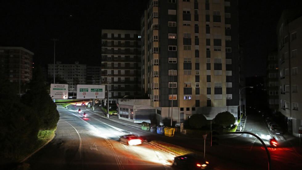 Los faros de unos automóviles iluminan una calle a oscuras por el apagón en toda la península ibérica, el 28 de abril de 2025 en la ciudad gallega de Vigo, al noroeste de España