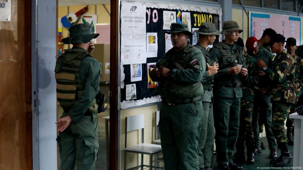 Un grupo de soldados uniformados guardan fila para votar en Caracas.