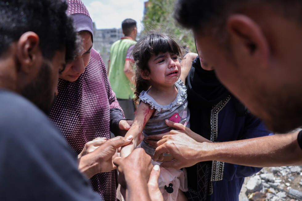 Varios palestinos atienden a una niña herida en un bombardeo israelí en el barrio de Saftawi, al oeste de Jabaliya, en el norte de la Franja de Gaza, el 27 de mayo de 2025