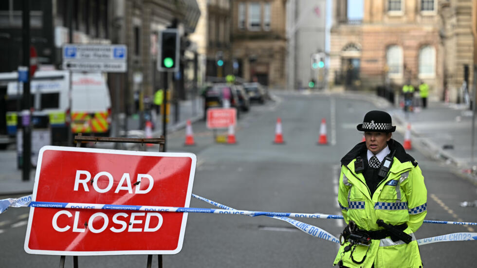 Una agente monta guardia junto a un cartel de 'calle cortada' en la zona acordonada por la policía tras el atropello de la víspera durante la celebración del título liguero del Liverpool, el 27 de mayo de 2025 en el centro de la ciudad inglesa