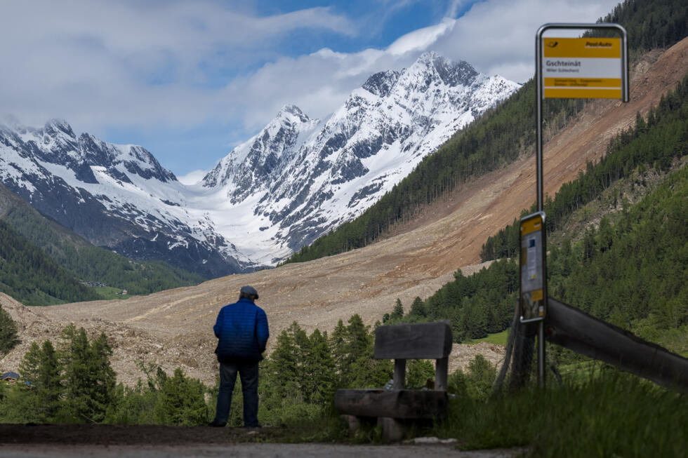 Un hombre observa los efectos del deslizamiento de tierra desde un mirador en Wiler, al día siguiente de que el enorme glaciar del Abedul se desprendiera y destruyera el pueblo evacuado de Blatten, el 29 de mayo de 2025 en los Alpes suizos