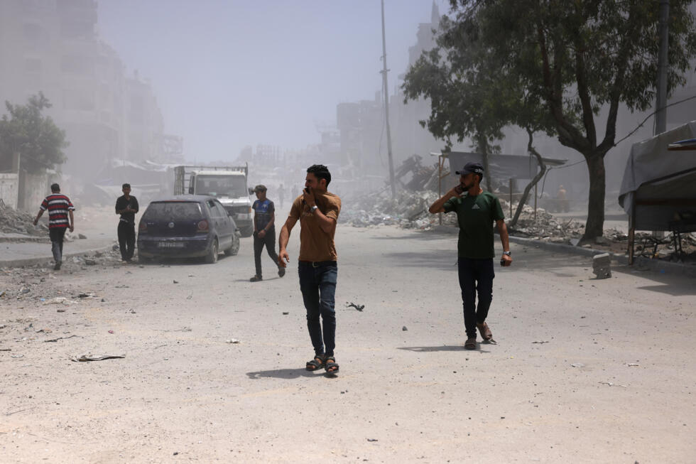 Varios palestinos se cubre el rostro por el polvo y el humo tras un ataque israelí contra una casa cercana en Jabaliya, el 1 de junio de 2025 al norte de la Franja de Gaza