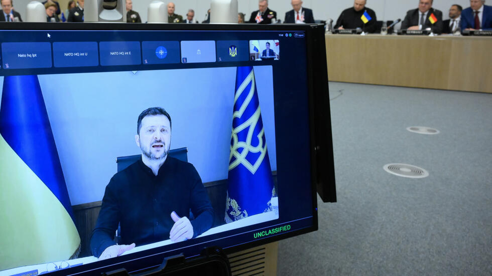 El presidente ucraniano, Volodimir Zelenski, aparece en pantalla al inicio de la reunión de la OTAN celebrada en la sede central de la alianza militar, el 4 de junio de 2025 en Bruselas