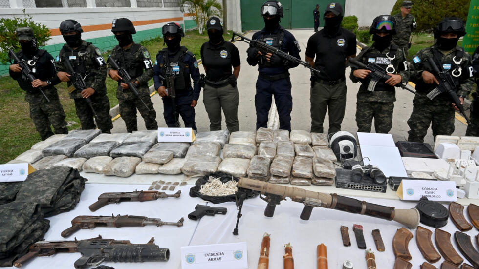 Policías militares custodian varias armas de grueso calibre y lanzacohetes decomisados en el Centro Penitenciario Nacional de Tamara, a 20 km al norte de Tegucigalpa, durante una rueda de prensa el 4 de junio de 2025
