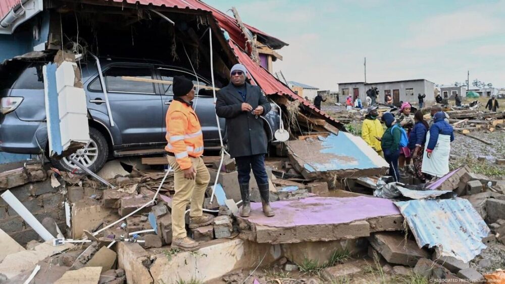 Un grupo de personas junto a los escombros de una vivienda tras el paso del agua en inundaciones en Mthatha, Sudáfrica. (11.06.2025).