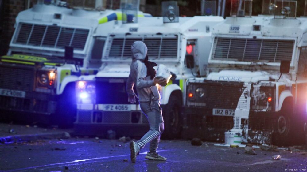 Un manifestante lanza objetos a coches policiales durante las protestas en Ballymena.