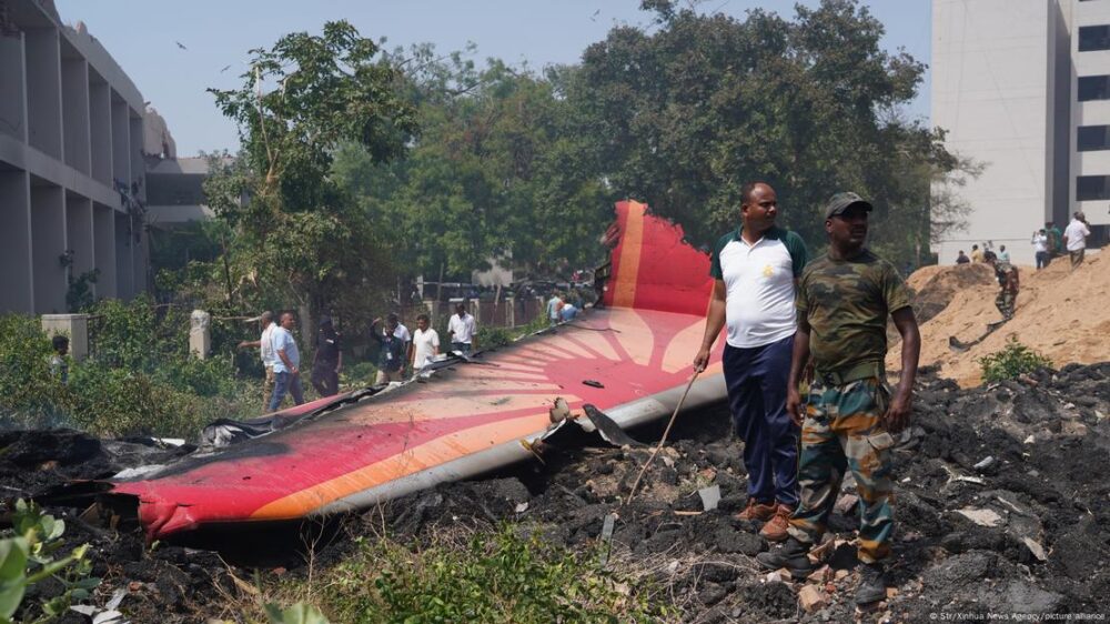 Un hombre junto a restos del avión de Air India siniestrado en las cercanías del aeropuerto de Ahmedabad, Gujarat, al despegar. 