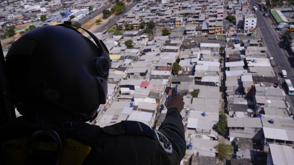 Un militar ecuatoriano lanza panfletos desde un helicóptero para incentivar las denuncias ciudadanas a criminales, el 13 de junio de 2025
