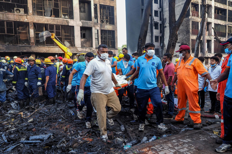 Los equipos de rescate retiran el cuerpo de una víctima de la zona residencial donde se estrelló el vuelo 171 de Air India en Ahmedabad, el 12 de junio de 2025