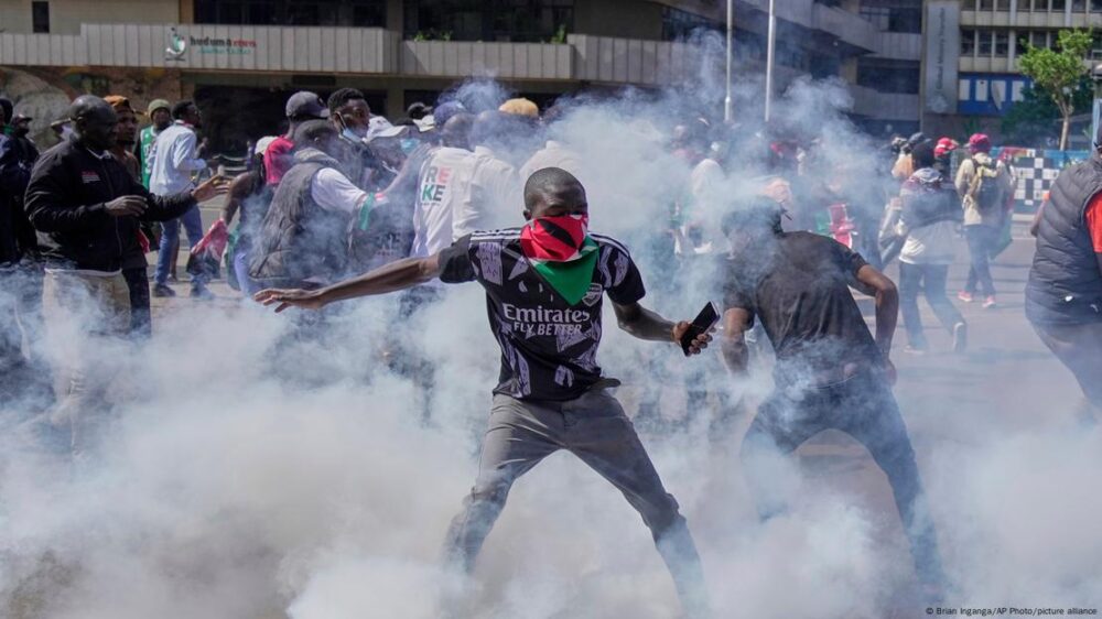 Con el rostro cubierto con un pañuelo, manifestantes se dispersan mientras la policía les dispara gases lacrimógenos durante una manifestación en el centro de Nairobi, Kenia.