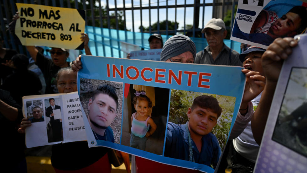 Un manifestante sostiene carteles con la imagen de un detenido pidiendo su liberación en una manifestación organizada por MOVIR (Movimiento de Víctimas del Régimen) frente a la Asamblea Legislativa en San Salvador el 25 de junio de 2025.Cien personas se manifestaron en San Salvador para exigir la no renovación del Decreto 803, que estipula que la Fiscalía de El Salvador tiene un plazo de dos años para presentar pruebas contra los detenidos durante el decreto del régimen de excepción del Presidente de El Salvador, Nayib Bukele, hace tres años para combatir las pandillas criminales.