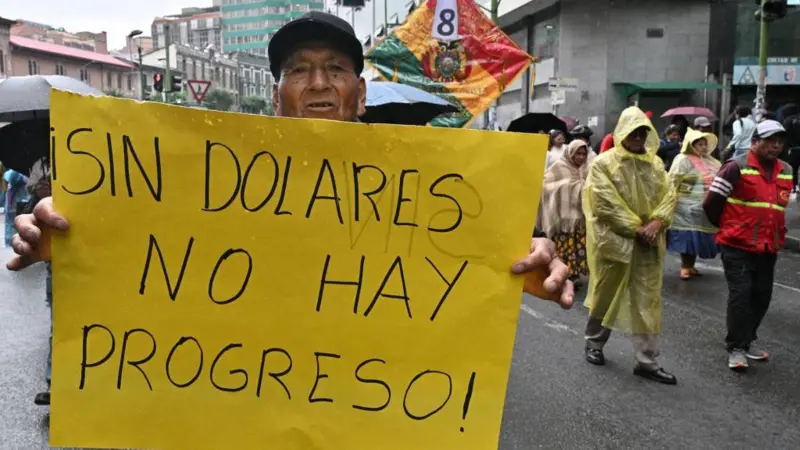 Hombre con un cartel en protesta por la economia boliviana