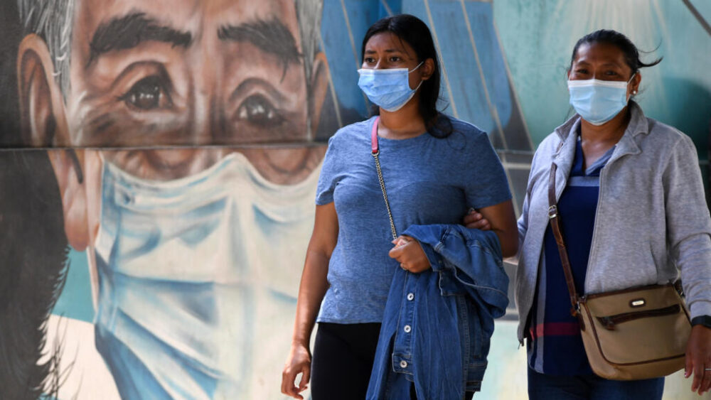 Mujeres usan mascarillas mientras caminan por una avenida de Tegucigalpa el 24 de julio de 2025.
