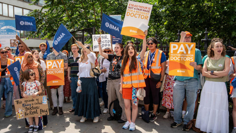 El personal sostiene pancartas mientras permanece de pie en una línea de piquete durante el primer día de huelga de médicos residentes frente al hospital St Thomas, en el centro de Londres, el 25 de julio de 2025. Miles de médicos británicos iniciaron una huelga de cinco días a principios del 25 de julio después de que las conversaciones con el gobierno laborista para un nuevo aumento salarial no llegaran a un acuerdo. La medida se produce después de que los médicos aceptaran en septiembre una oferta de aumento salarial del 22,3 por ciento en dos años. (Foto de Niklas HALLE'N / AFP)
