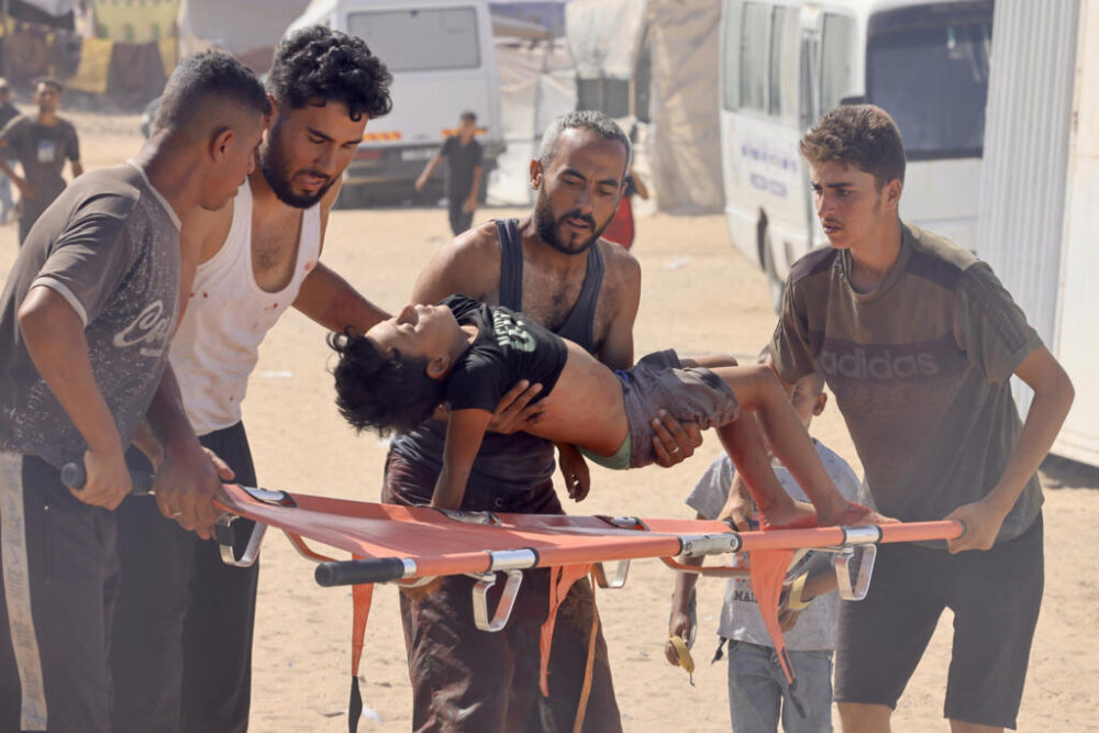 Cuatro personas llevan a un hospital de campaña a un joven palestino que resultó herido cuando iba a buscar ayuda humanitaria en la región de Rafah, en el sur de la Franja de Gaza, el 30 de julio de 2025
