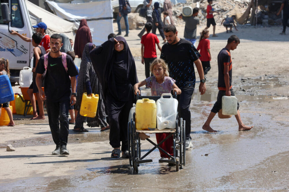 Unos palestinos se llevan garrafas de agua potable de un punto de distribución el 1 de agsoto de 2025 en la ciudad de Gaza