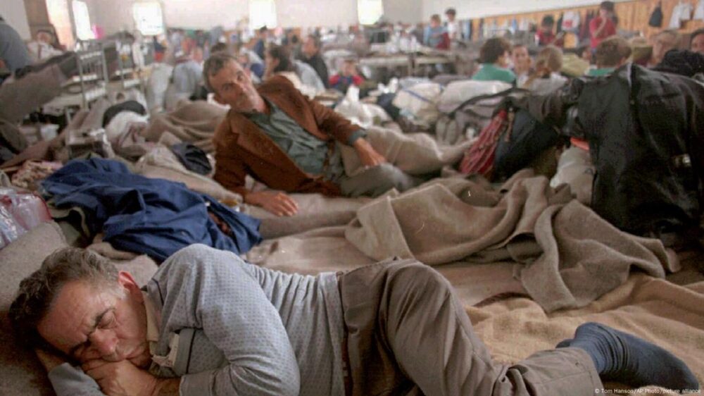 Serbios de Bosnia que huyeron de sus hogares durante la operación 'Tormenta' de Croacia, en 1995, duermen en el suelo en una escuela, en un refugio improvisado.