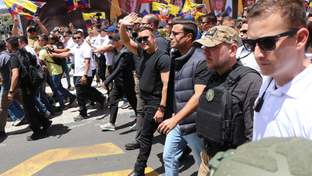 El presidente de Ecuador, Daniel Noboa, vestido con chaleco antibalas, saluda a sus seguidores durante una marcha contra la decisión de la Corte Constitucional de censurar varios artículos de leyes recientes en Quito el 12 de agosto de 2025.