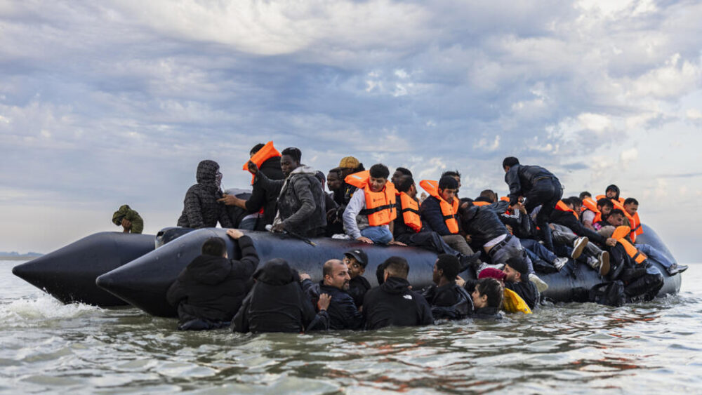 Los migrantes intentan abordar una embarcación en un intento de cruzar el Canal de la Mancha frente a la playa de Gravelines, en el norte de Francia, el 12 de agosto de 2025.