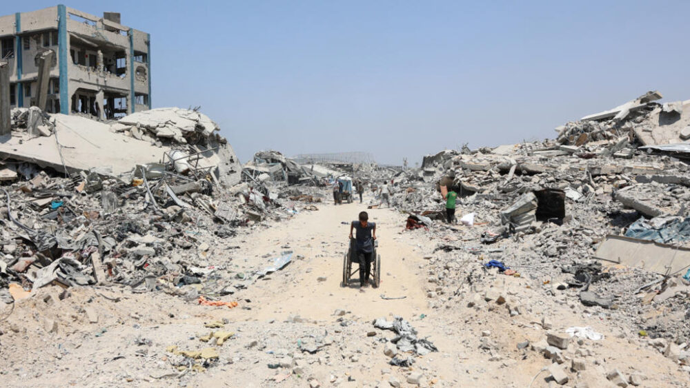 Un niño palestino arrastra una silla de ruedas en el barrio de Al Tufah, en Ciudad de Gaza, el 14 de agosto de 2025