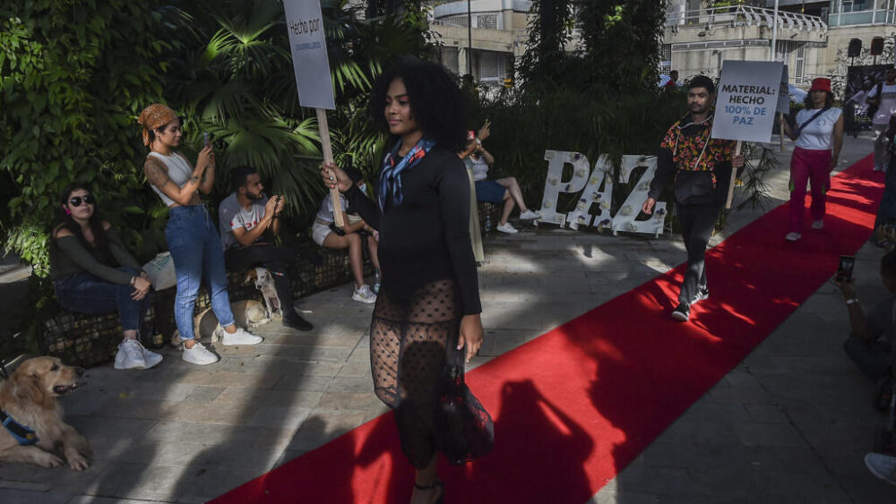 Modelos con carteles presentan sus creaciones en el desfile de moda Paz-arela, en el que exguerrilleros de las FARC y víctimas del conflicto mostraron sus colecciones en Medellín, Colombia, el 4 de diciembre de 2021. (Foto de ilustración).