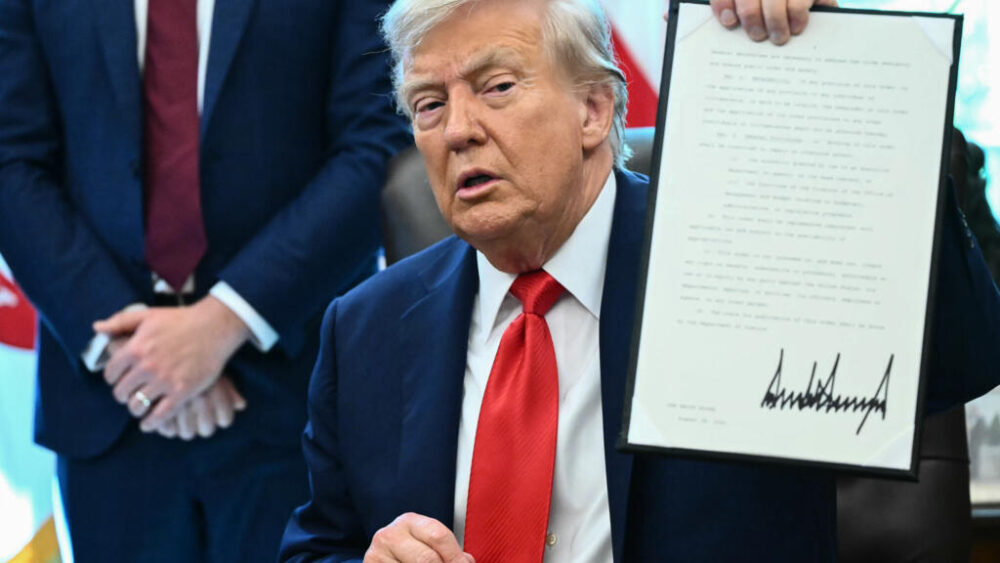 El presidente estadounidense, Donald Trump, sostiene una orden ejecutiva en el Despacho Oval.