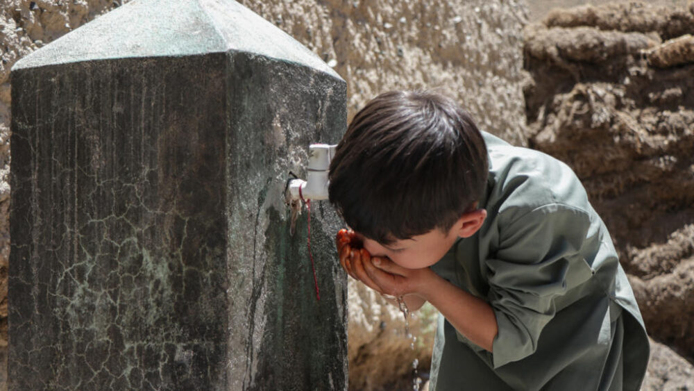 Un niño bebe agua del grifo de una fuente en Qavariyak, en la provincia de Bamiyán, el 18 de junio de 2025 en Afganistán