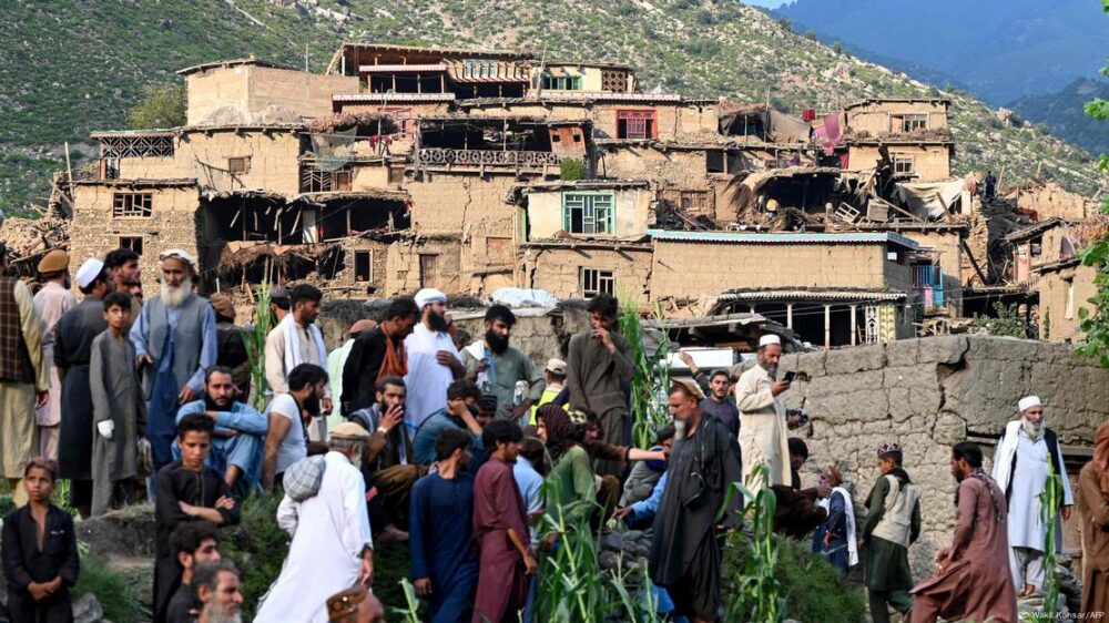 Un grupo de personas recorre el lugar junto a casas destruidas por el terremoto en la localidad de Mazar Dara, Kunar, Afganistán.