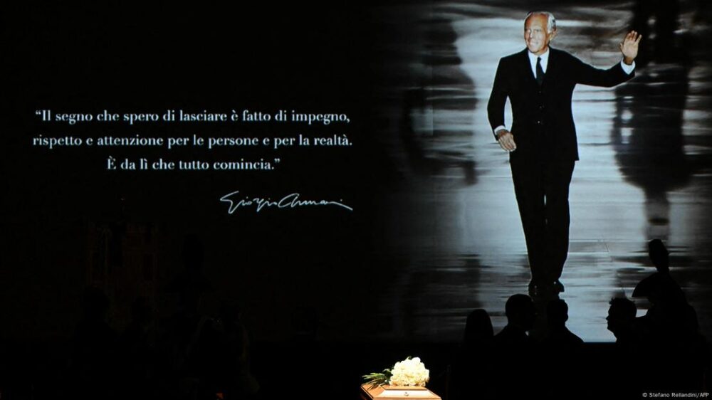 El féretro con la proyección detrás de una imagen de Armani y la cita, firmada por el modista.